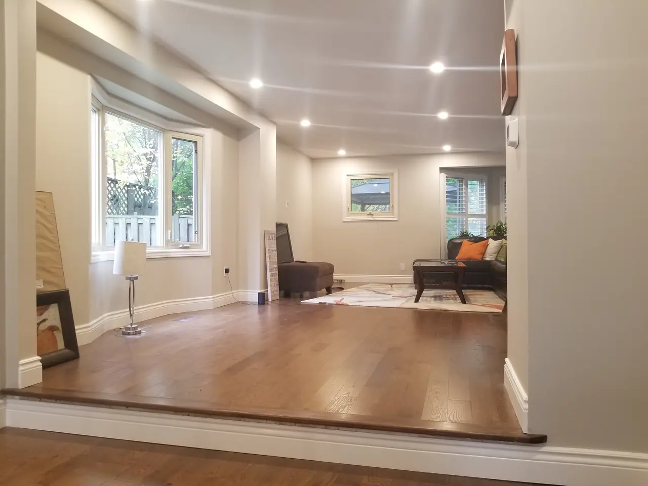 Open living area with a bay window and dark hardwood after a whole-home renovation.