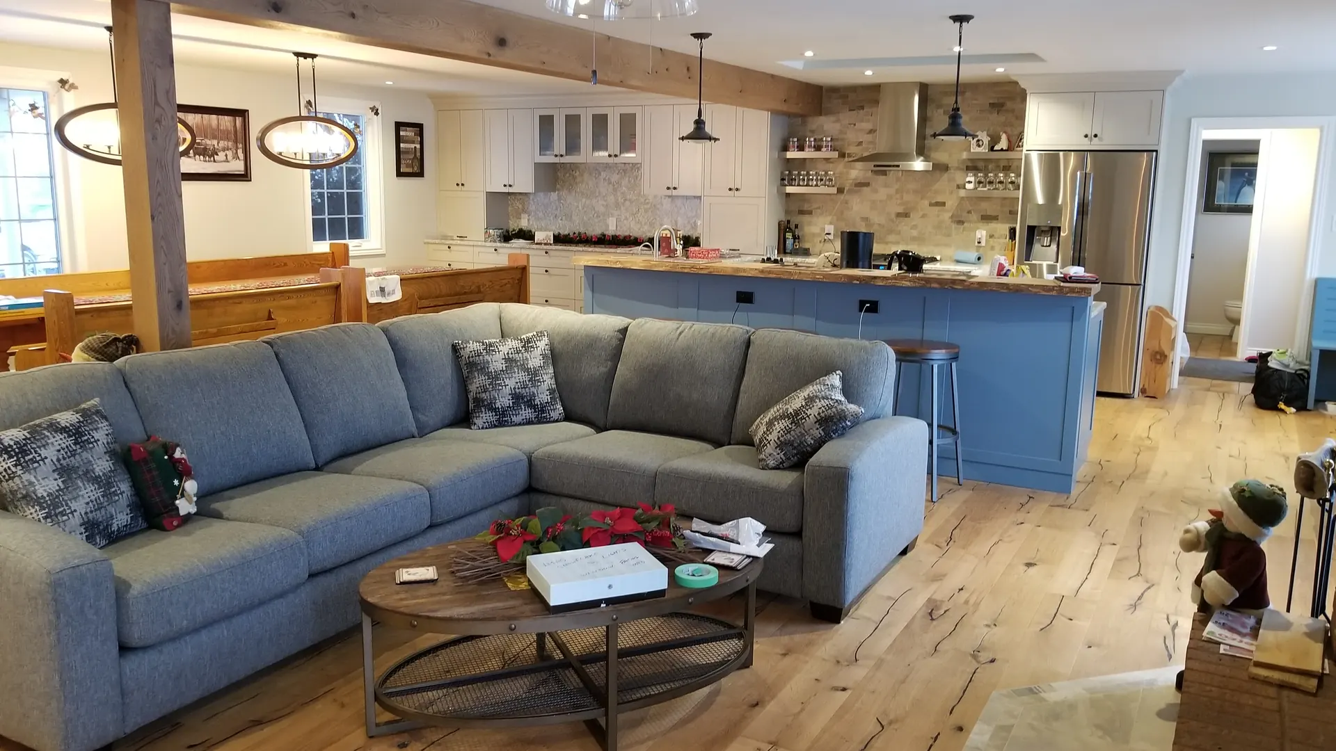 Open-concept MATCON renovation with a kitchen, timber beam, and family room.