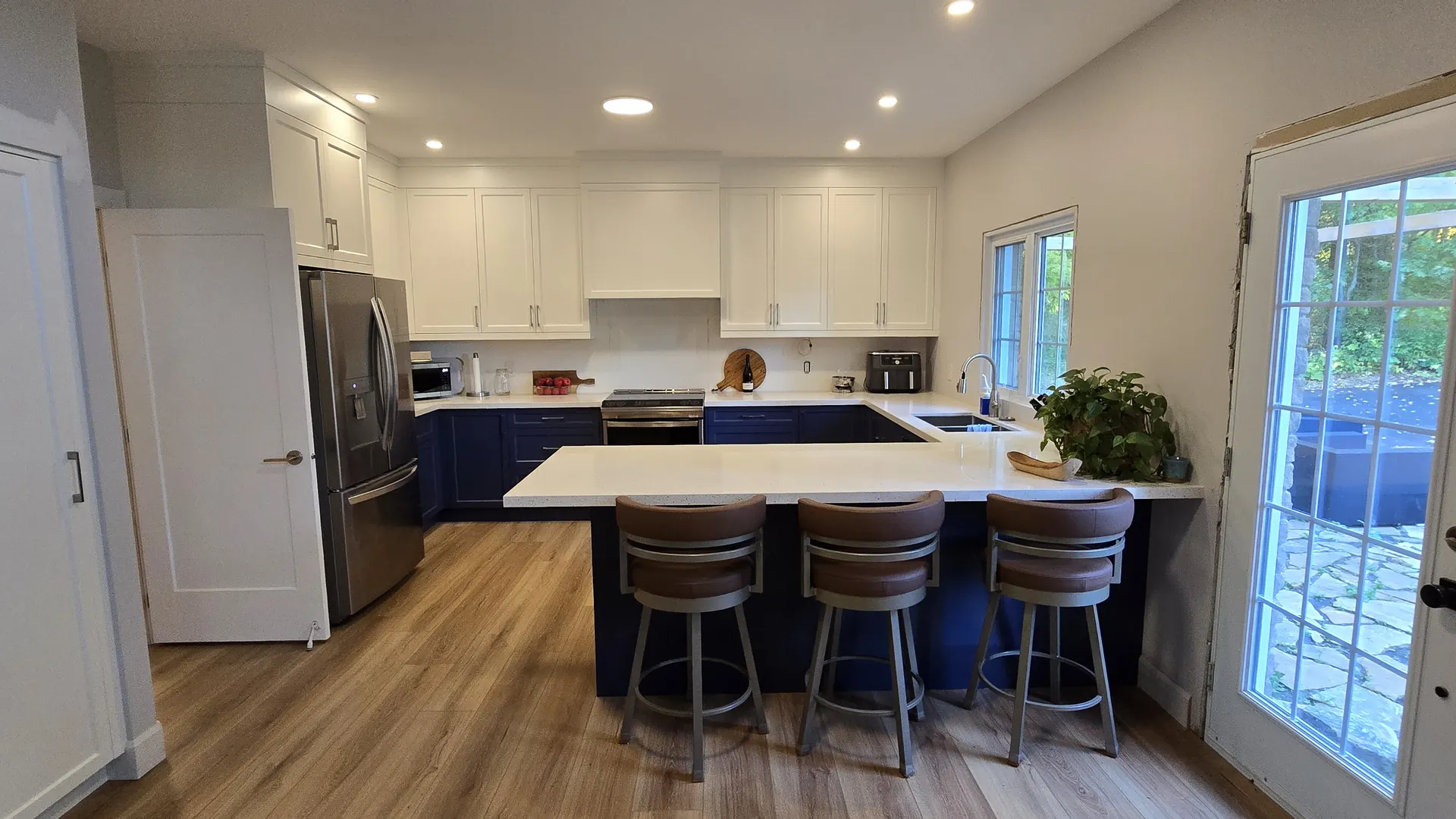 Finished MATCON kitchen renovation with a blue island and white cabinetry.