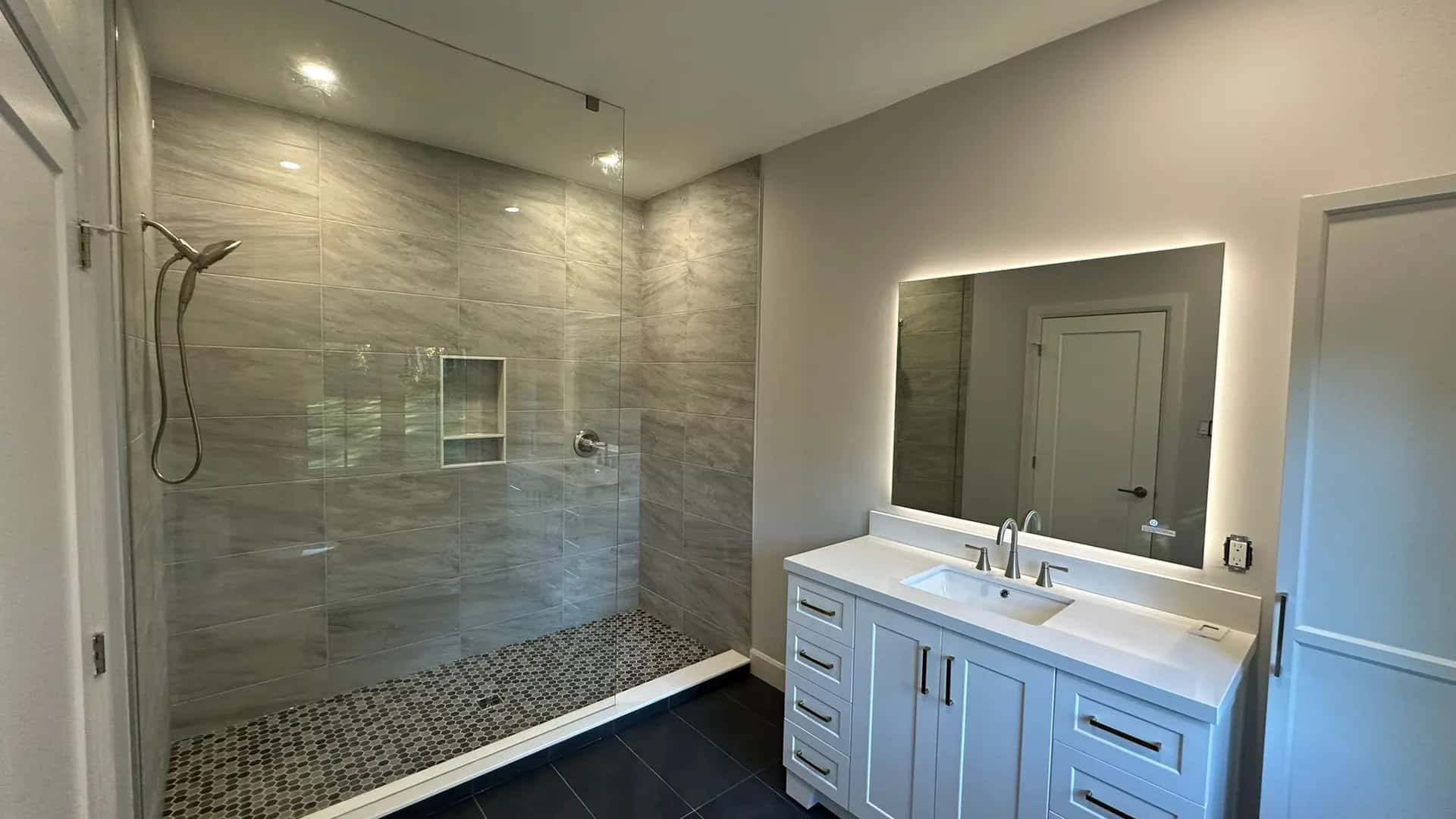 Finished MATCON bathroom with stone shower wall and custom vanity.