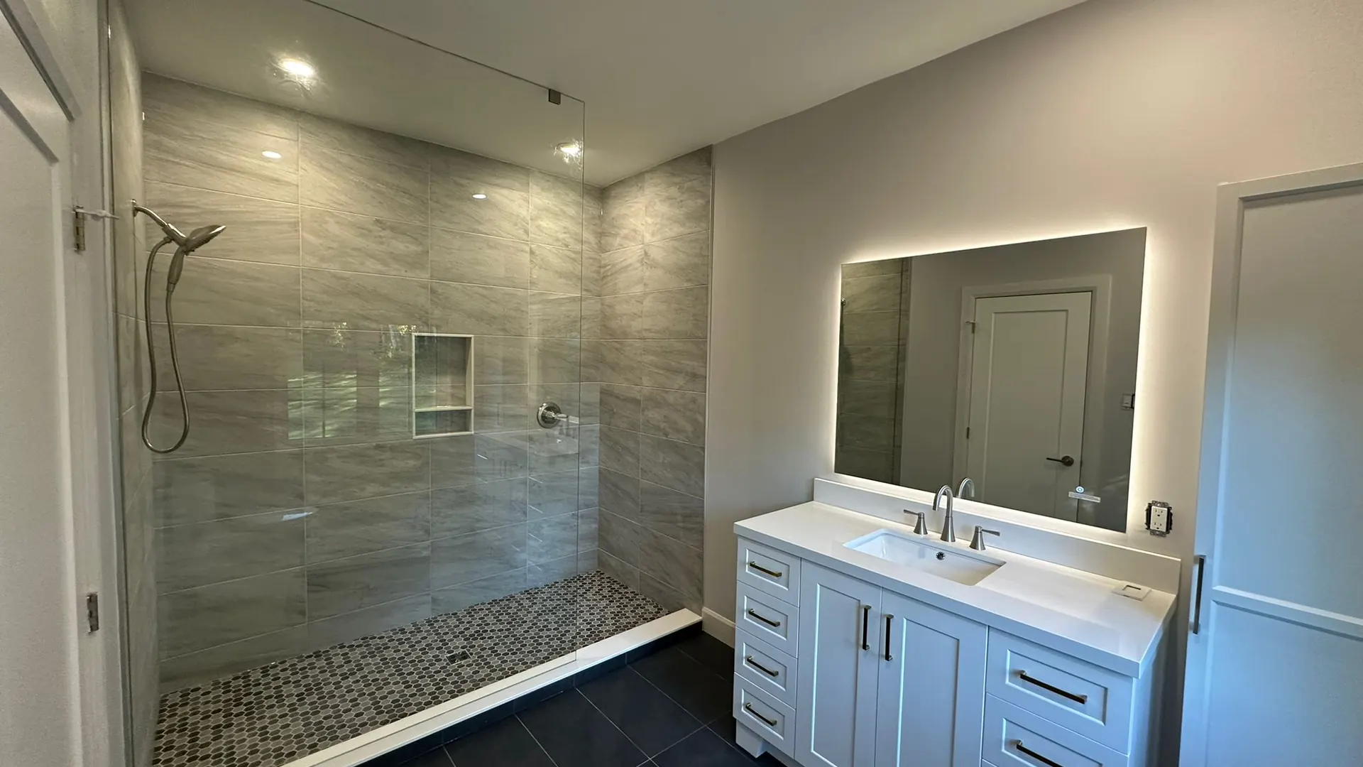 Finished MATCON bathroom with stone shower wall and custom vanity.