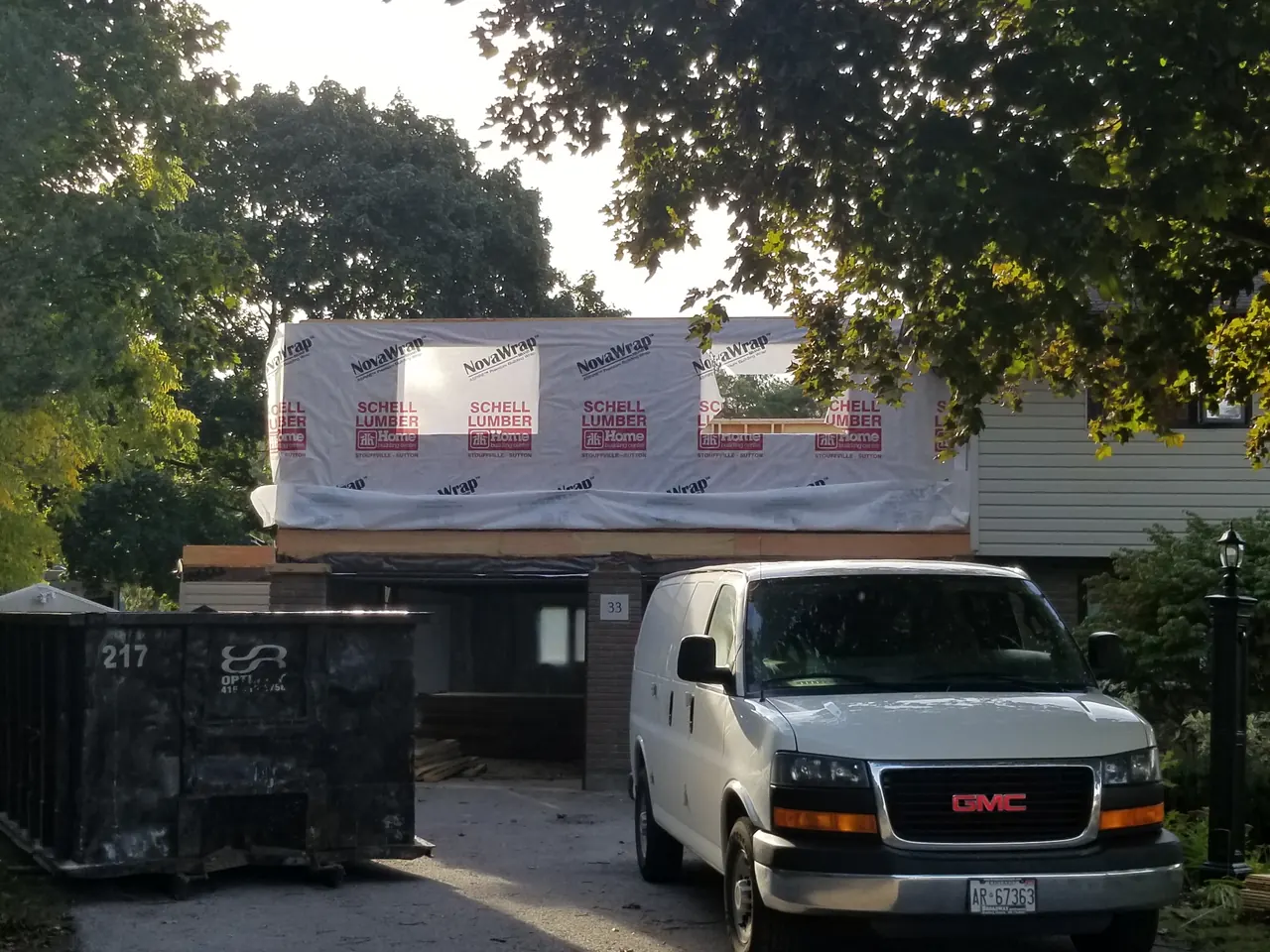 A new second storey framed and house-wrapped above an existing home during a second-storey addition.
